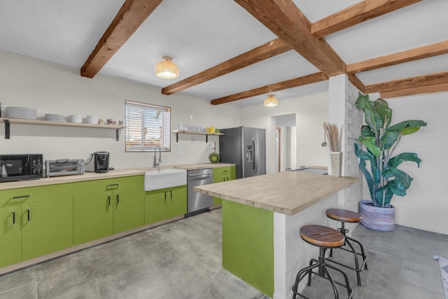 kitchen featuring sink, a breakfast bar area, green cabinets, stainless steel appliances, and beam ceiling