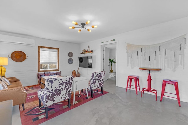 living room featuring a notable chandelier, concrete floors, and an AC wall unit