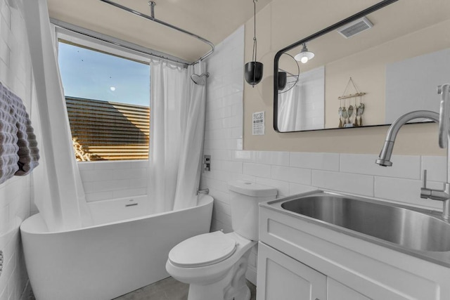 full bathroom featuring vanity, tile walls, shower / tub combo with curtain, and toilet