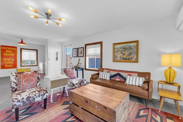 living room with concrete flooring and a notable chandelier