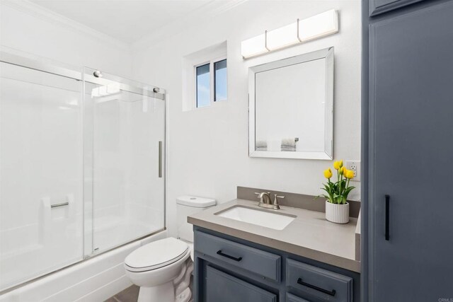 full bathroom with vanity, ornamental molding, enclosed tub / shower combo, and toilet