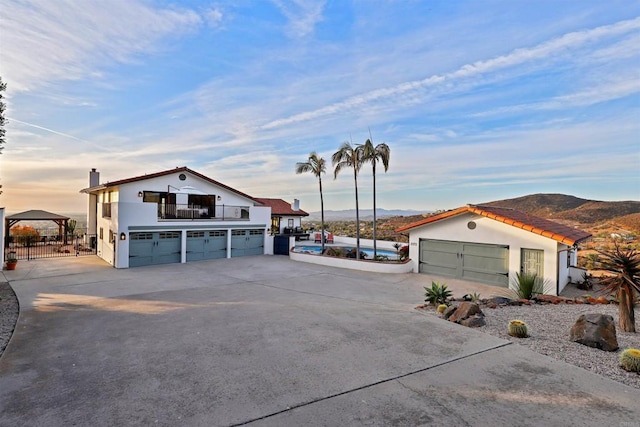 view of front of house featuring a mountain view and a balcony