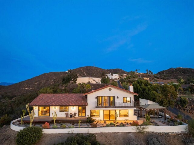 back of house with a gazebo and a mountain view