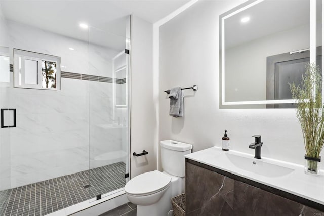 bathroom featuring toilet, vanity, and walk in shower