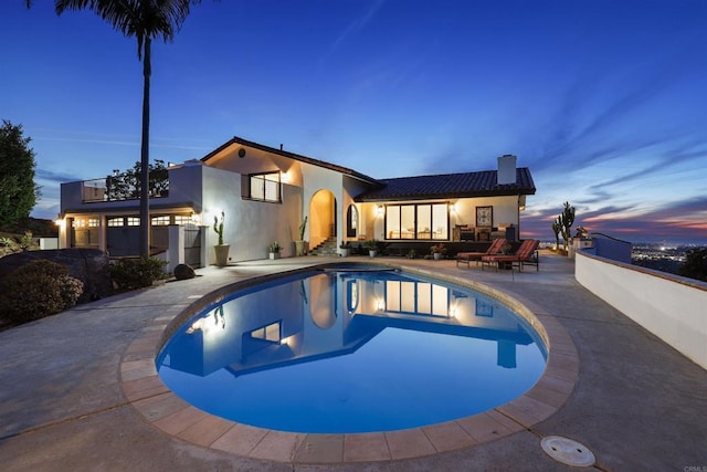 pool at dusk with a patio