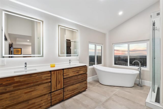 bathroom with vaulted ceiling, a tub, and vanity