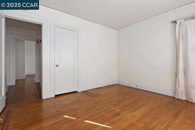 unfurnished bedroom with hardwood / wood-style flooring and a closet