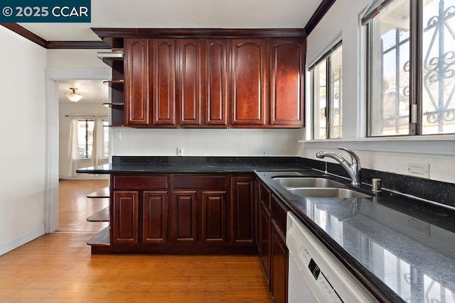 kitchen with sink, dark stone counters, ornamental molding, white dishwasher, and light hardwood / wood-style floors