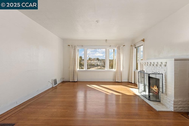 unfurnished living room with hardwood / wood-style floors and a fireplace