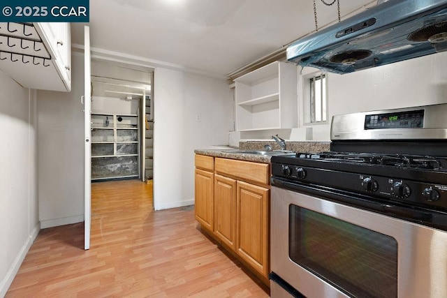 kitchen featuring extractor fan, stainless steel range with gas cooktop, light hardwood / wood-style floors, and sink