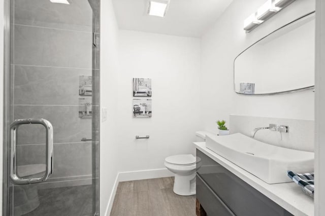 bathroom featuring vanity, toilet, an enclosed shower, and hardwood / wood-style floors