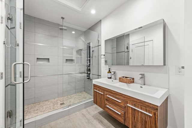 bathroom with walk in shower and vanity