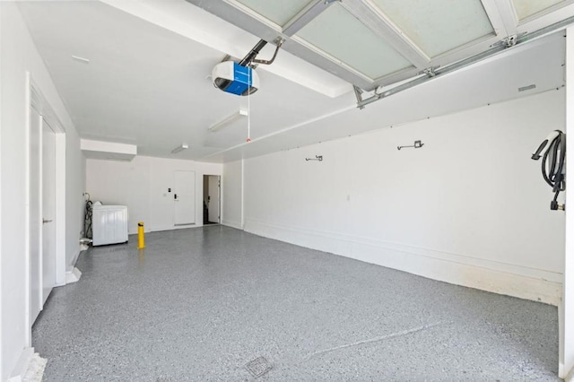 garage with a garage door opener and washer / clothes dryer