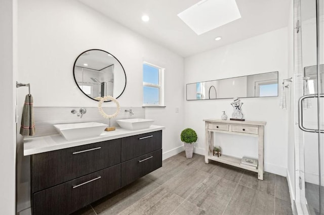 bathroom featuring vanity, walk in shower, and a skylight