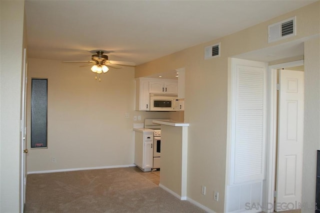 kitchen with white cabinetry, light colored carpet, electric range, and ceiling fan