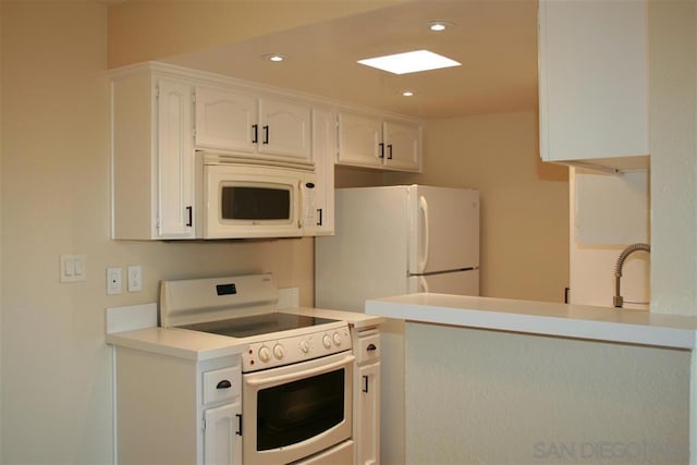 kitchen featuring white cabinetry, sink, white appliances, and kitchen peninsula