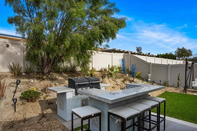 view of patio featuring exterior bar and a grill