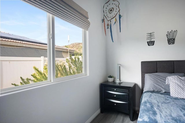 bedroom with hardwood / wood-style flooring and multiple windows