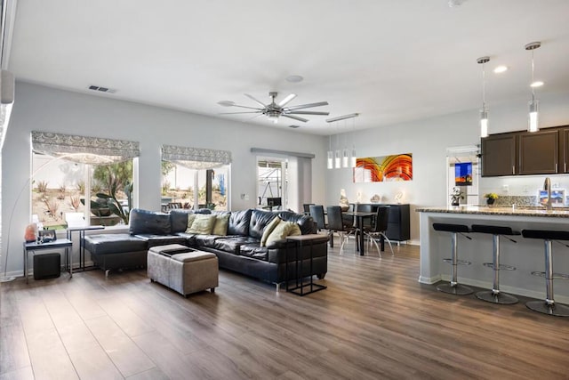 living room with ceiling fan and dark hardwood / wood-style floors