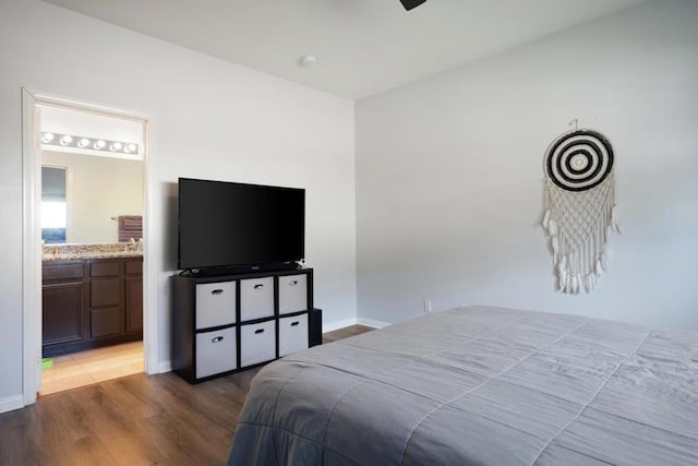 bedroom with wood-type flooring and connected bathroom