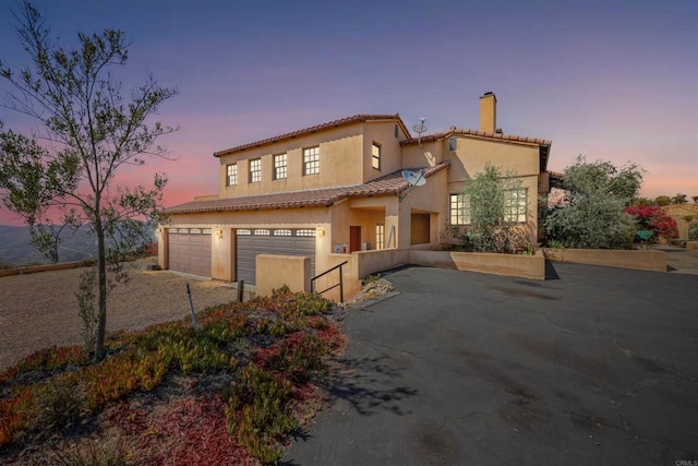 mediterranean / spanish house featuring a garage