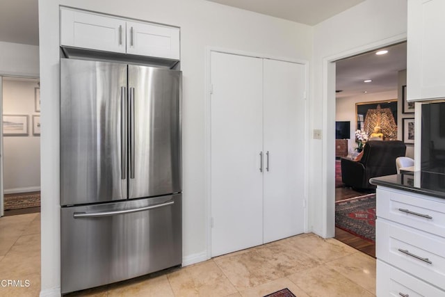 kitchen with stainless steel fridge and white cabinets