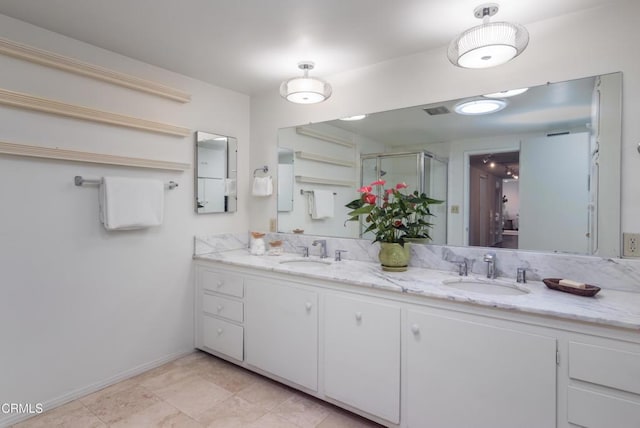 bathroom featuring a stall shower, a sink, and double vanity