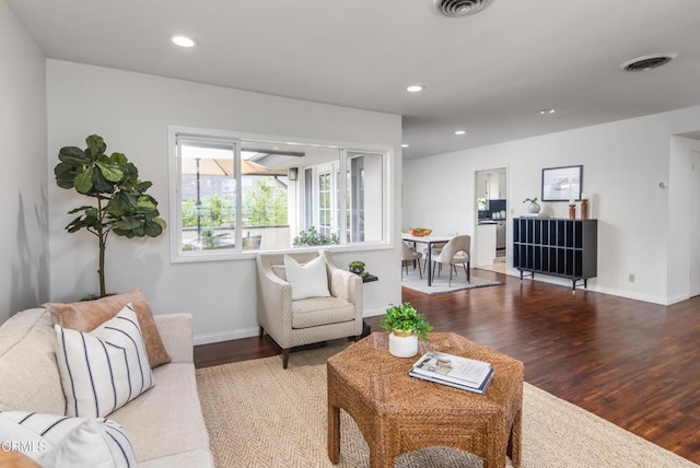 living room with baseboards, wood finished floors, visible vents, and recessed lighting