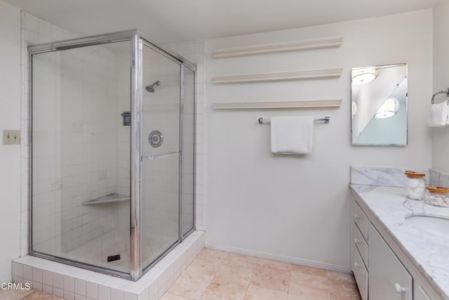 bathroom featuring baseboards, a shower stall, and vanity