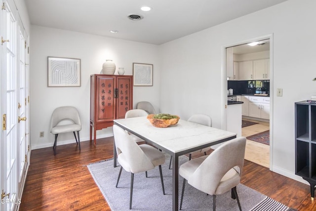 dining area featuring visible vents, baseboards, and wood finished floors