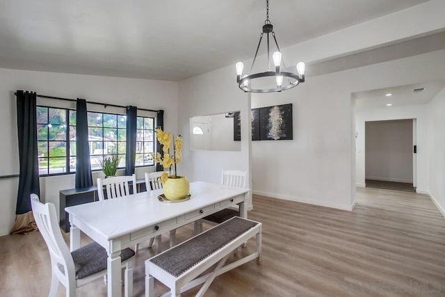 dining space featuring a notable chandelier and light wood-type flooring