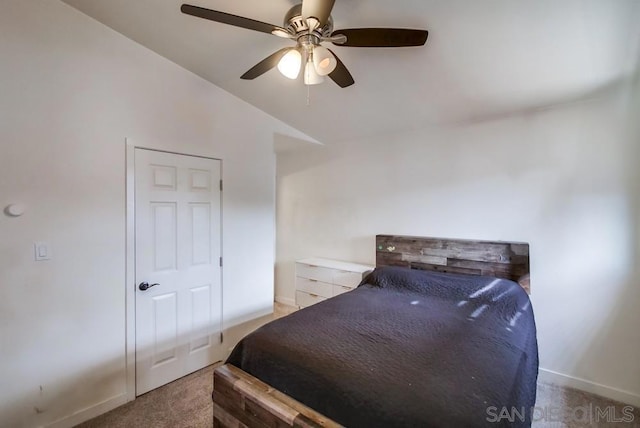 carpeted bedroom with ceiling fan and vaulted ceiling