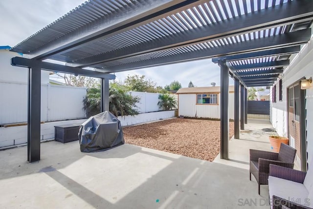 view of patio / terrace featuring area for grilling, an outbuilding, and a pergola