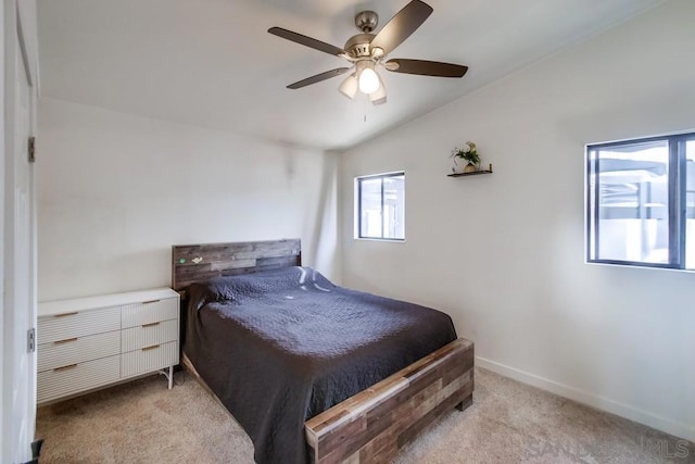 carpeted bedroom with vaulted ceiling and ceiling fan