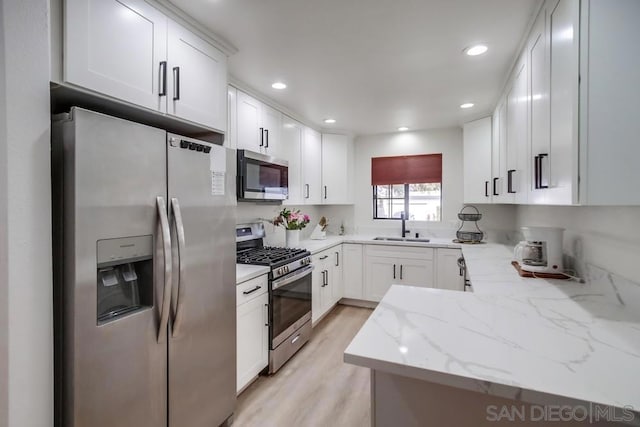 kitchen featuring light stone counters, sink, white cabinets, and appliances with stainless steel finishes