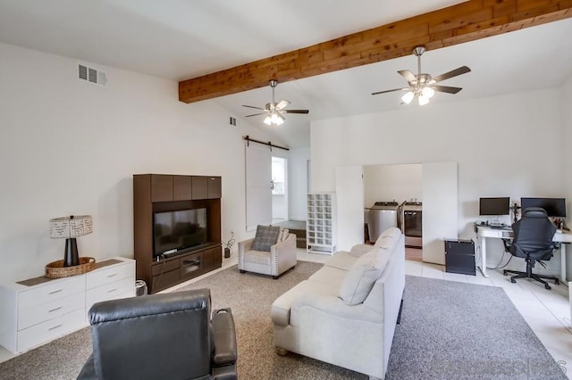 living room featuring lofted ceiling with beams, washing machine and dryer, a barn door, and ceiling fan