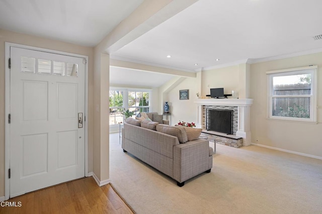 living room featuring crown molding, a fireplace, and light wood-type flooring