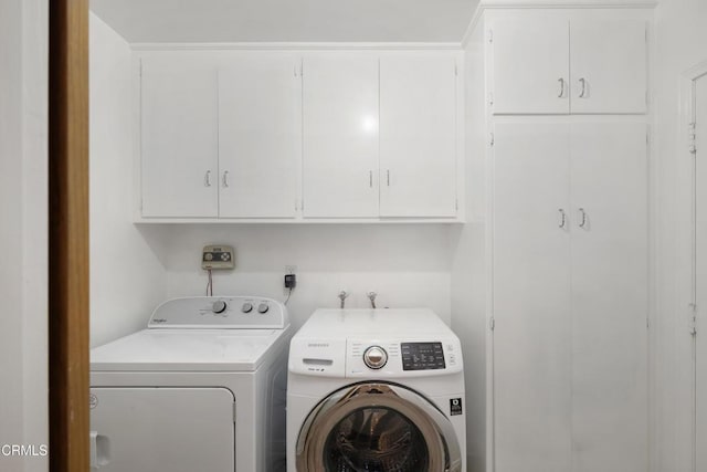 washroom featuring washing machine and dryer and cabinets