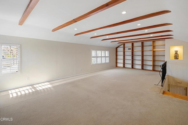 unfurnished living room with lofted ceiling with beams and light carpet