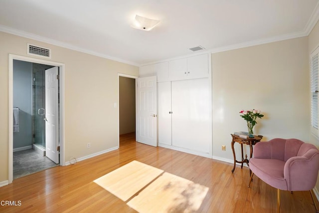 sitting room with crown molding and hardwood / wood-style floors