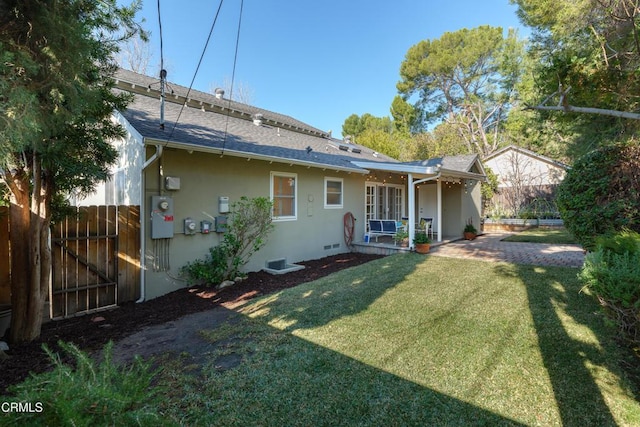 rear view of property featuring a yard and a patio area