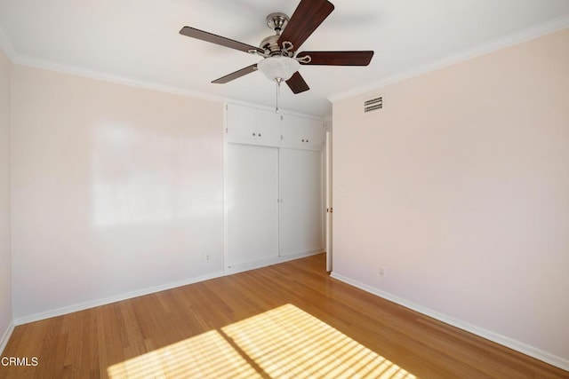 empty room featuring ceiling fan, ornamental molding, and hardwood / wood-style floors