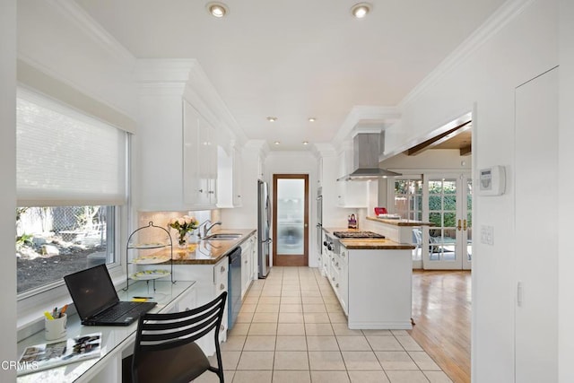 kitchen with sink, ventilation hood, white cabinets, and appliances with stainless steel finishes