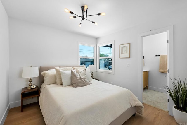 bedroom with hardwood / wood-style floors and an inviting chandelier