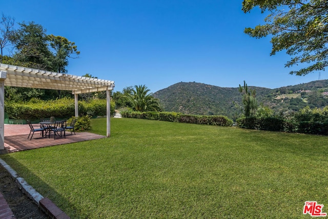 view of yard featuring a pergola, a patio area, and a mountain view