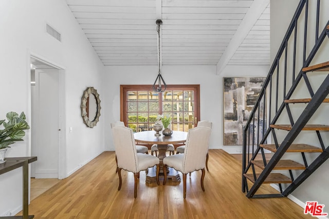 dining area with vaulted ceiling and light wood-type flooring