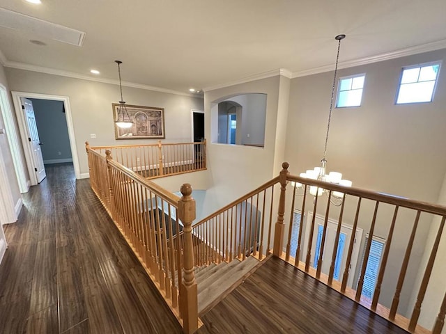 staircase featuring an inviting chandelier, crown molding, and hardwood / wood-style flooring