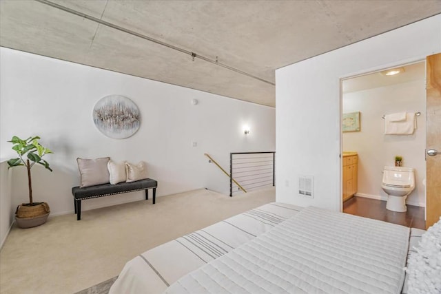 bedroom featuring ensuite bath and carpet flooring