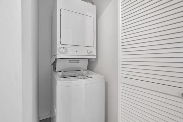 clothes washing area featuring stacked washer and clothes dryer