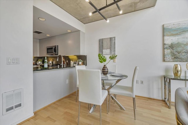 dining area featuring sink and light hardwood / wood-style flooring